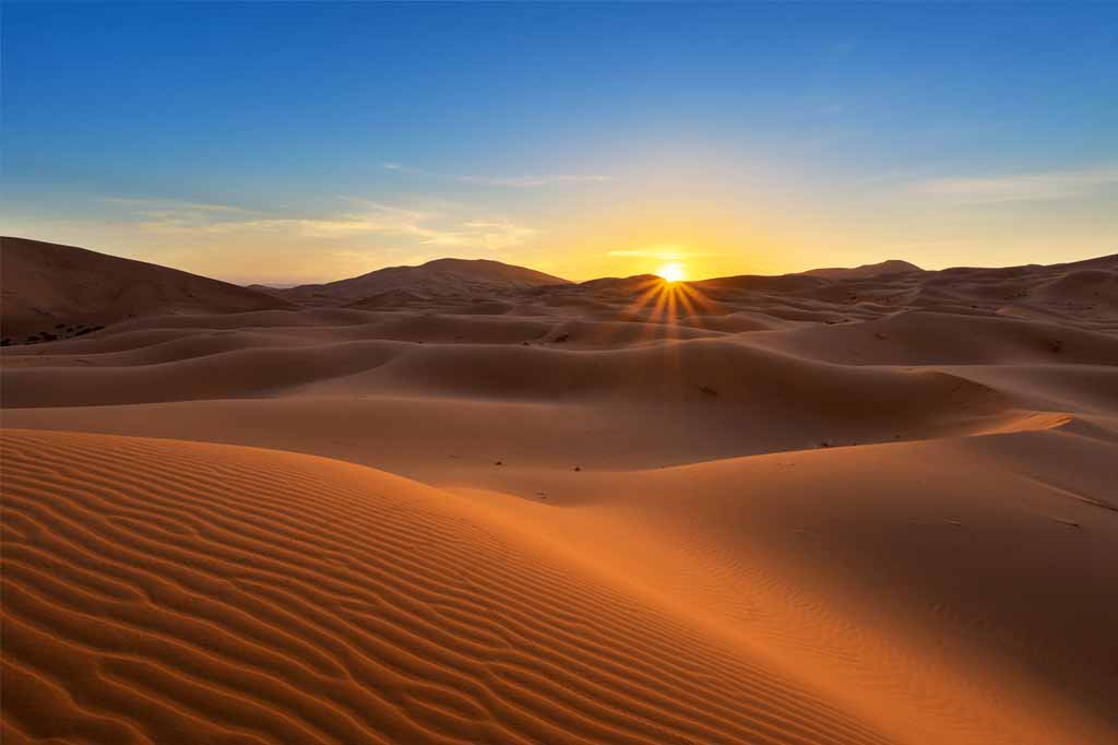 Morocco Travel FAQ: Everything You Need to Know 2 Camel trekking at sunset in the Merzouga desert, a highlight of the top Morocco tours