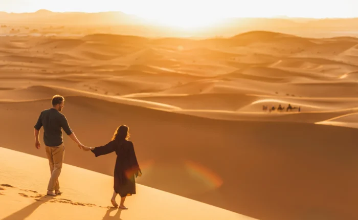 Morocco Travel FAQ: Everything You Need to Know 7 Couple enjoying luxury tours to Morocco with a view of the Sahara desert dunes
